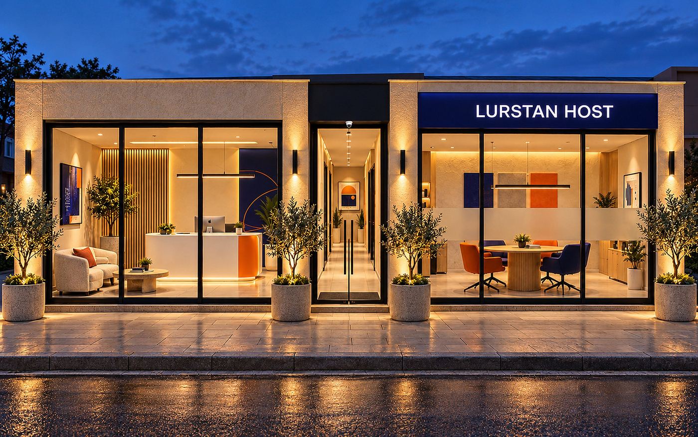 The Lurstan Host shopfront at dusk: black-framed glass, a lit sign and olive trees along the pavement